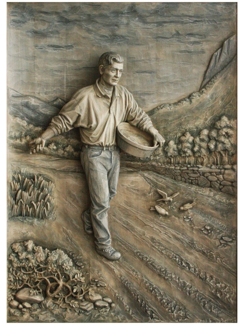A relief in lime: a man in an open shirt walks across a ploughed field casting seed from his bag, with birds on the ground and mountains behind.