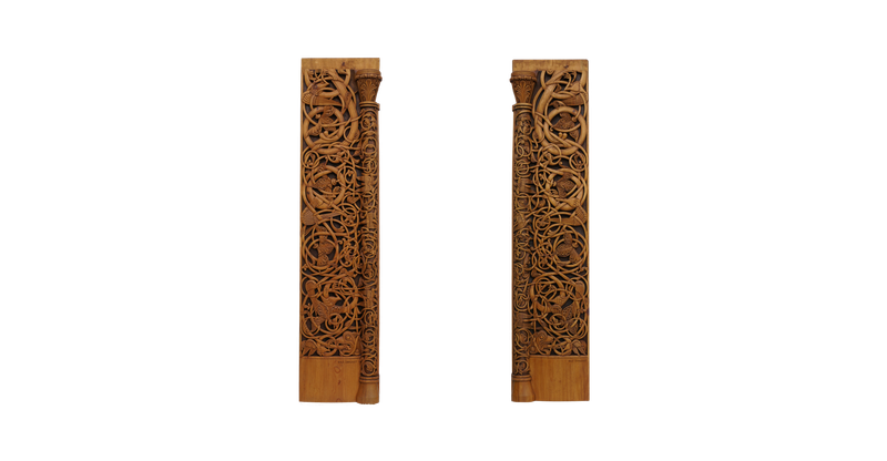 Two tall pine planks carved clean through with interlaced tendrils and beasts, a slender half-column and capital running down the inner edge of each.